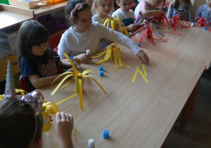 dzieci sklejają jabłka z papierowych pasków