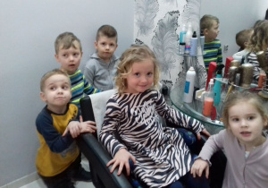 dzieci z zainteresowaniem słuchają informacji o zawodzie fryzjera