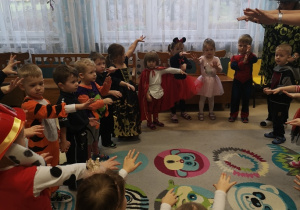 dzieci wykonuja figury taneczne wyciagając rączki do przodu