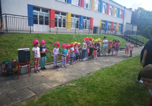 dzieci stoją w kapeluszach i uczestniczą w zabawie