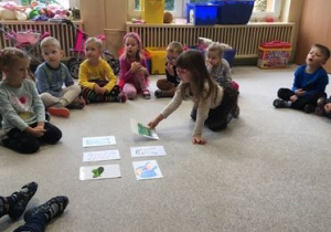 dzieci oglądają obrazki rozłożone na dywanie