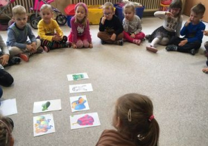 dzieci oglądają obrazki rozłożone na dywanie