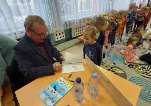 autor podpisuje książki dzieciom
