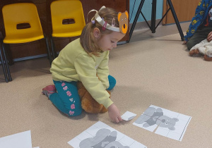 dziewczynka układa puzzle z misem