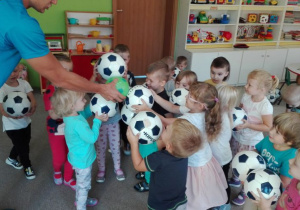 dzieci dotykają się piłkami