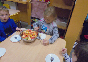 dzieci robią sałatkę owocową
