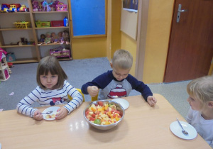 dzieci nakładają sobie sałatkę na talerzyki