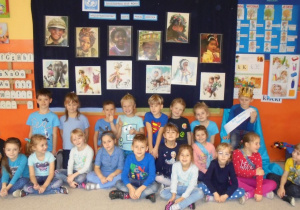 dzieci w grupie na tle kolorowych obrazków dzieci z róznych stron świata