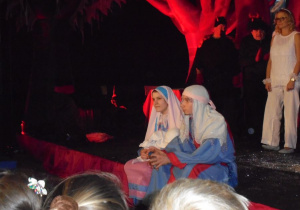 Józef i Maryja z dzieciątkiem siedzą na scenie
